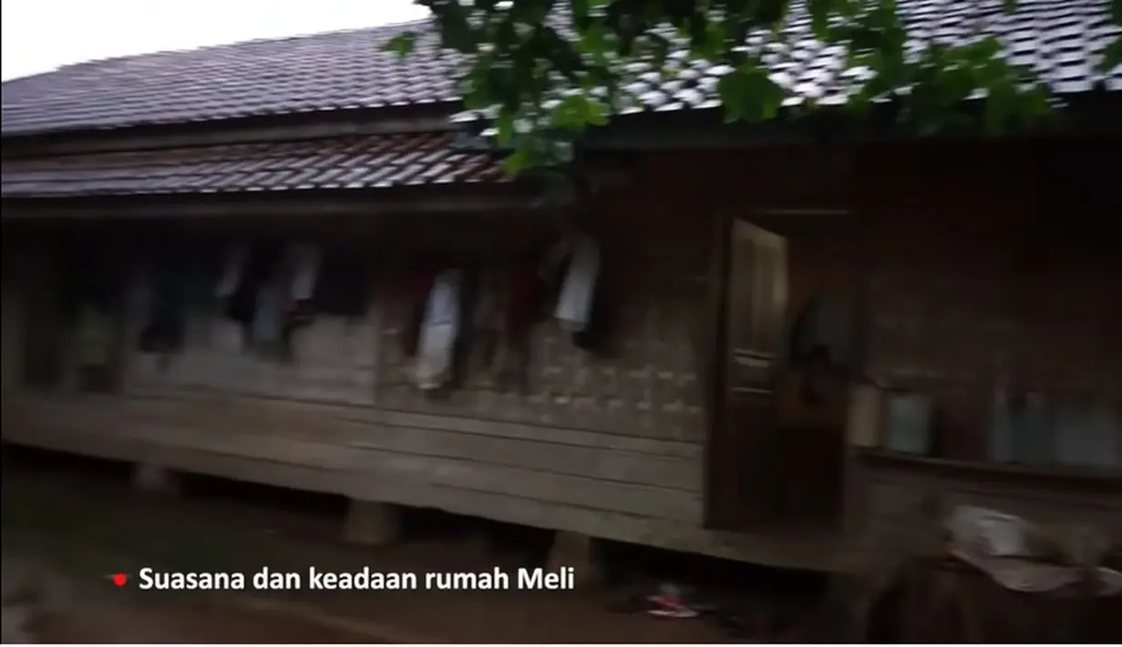 Rumah model lama dengan bangunan sederhana dan banyak dinding yang  menggunakan anyaman bambu. Tampak di bagian samping digunakan untuk mengantungkan beberapa pakaian. [Youtube/Melly Lee]