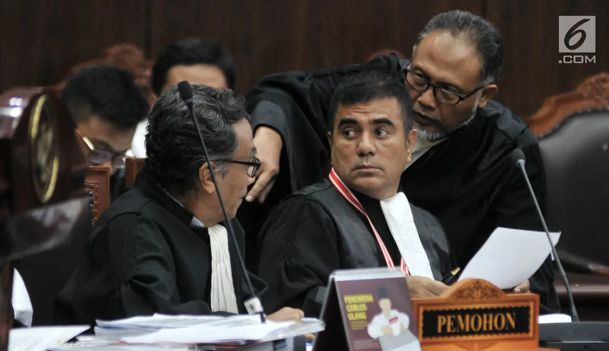 Kuasa hukum Pemohon, Bambang Widjojanto berbincang dengan kuasa hukum Pemohon lainnya saat sidang lanjutan sengketa Pilpres 2019 di Mahkamah Konstitusi, Jakarta, Rabu (19/6/2019). (merdeka.com/Iqbal S. Nugroho)