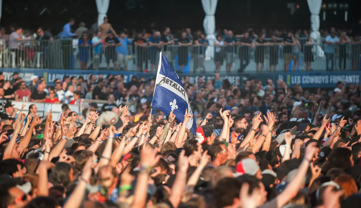 Ribuan penonton menyaksikan aksi panggung Metallica saat tampil di Festival d'ete de Quebec di Quebec City, Kanada (14/7). Ribuan penonton terhibur dengan aksi panggung band metal tersebut. (AFP Photo/Alice Chicheby)