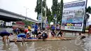 Tampak warga menyewakan perahu kayu kepada orang-orang yang ingin melintasi banjir, Jakarta, Senin (6/2/2015). Jasa gerobak Mematok harga Rp. 30 ribu untuk membawa motor sedangkan untuk per orang hanya Rp. 10 ribu. (Liputan6.com/Faizal Fanani)