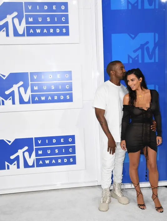 Kemesraan pasangan seleb, Kim Kardashian dan Kanye West di karpet merah penghargaan MTV VMA 2016 di New York, Minggu (28/8). Malam itu, Kanye West memilih T-shirt, jeans sampai sepatu yang seluruhnya berwarna putih. (AFP PHOTO/Angela Weiss)