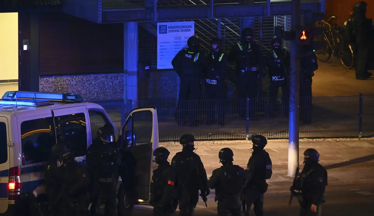 Polisi bersenjata di dekat lokasi penembakan di Hamburg, Jerman setelah satu atau lebih orang melepaskan tembakan di sebuah gereja, Kamis (9/3/2023). Surat kabar Bild melaporkan, insiden ini terjadi sekitar pukul 9 malam saat para korban berada di Gereja Saksi-saksi Yehuwa. (Jonas Walzberg/dpa via AP)