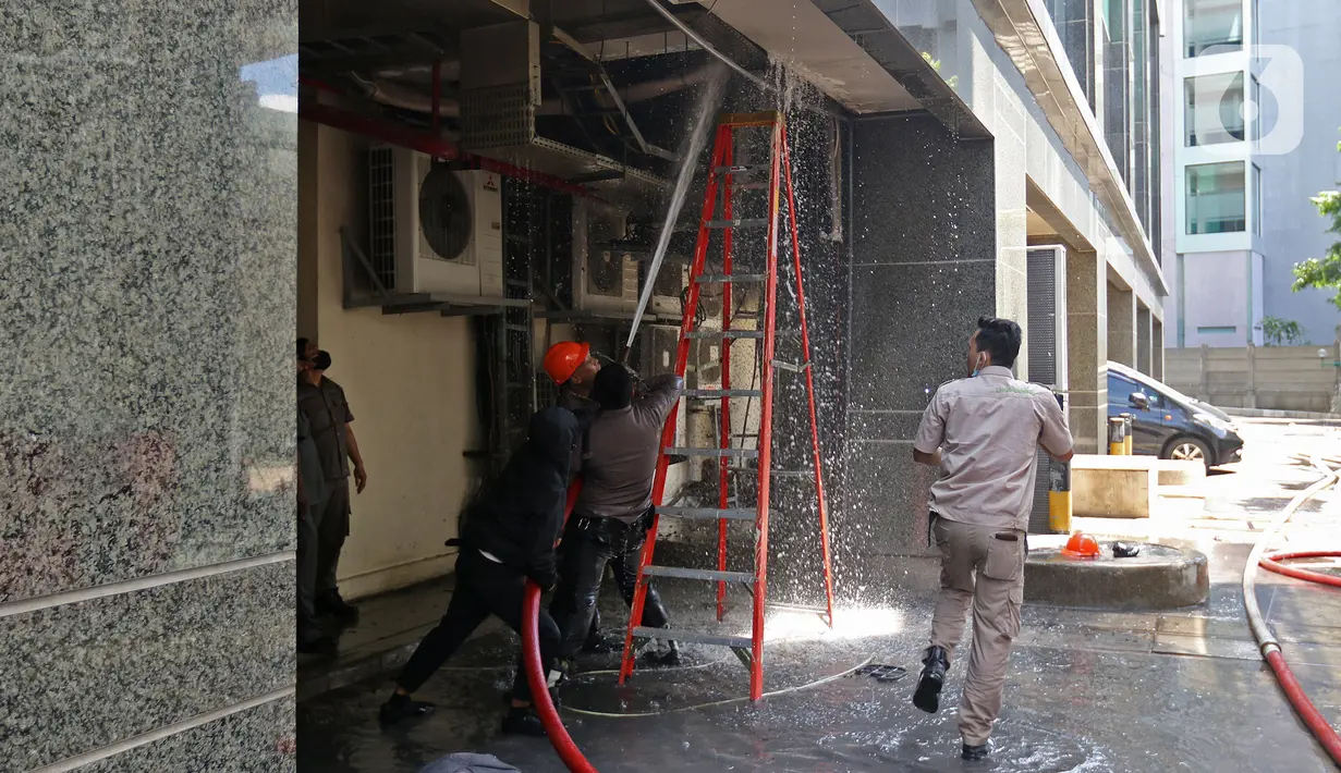 Petugas menyemprotkan air saat berusaha memadamkan kebakaran di Gedung Cyber 1, Jakarta, Kamis (2/12/2021). Sampai saat ini, penyebab kebakaran masih belum diketahui. (Liputan6.com/Herman Zakharia)