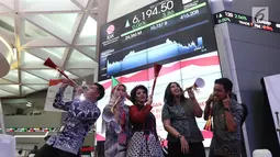 Sejumlah karyawan meniup terompet saat penutupan Indeks Harga Saham Gabungan (IHSG) 2018 di Kantor BEI, Jakarta, Jumat (28/12). Perdagangan IHSG 2018 ditutup menguat 0,06 persen atau 3,86 poin ke level 6.194,50. (Liputan6.com/Angga Yuniar)