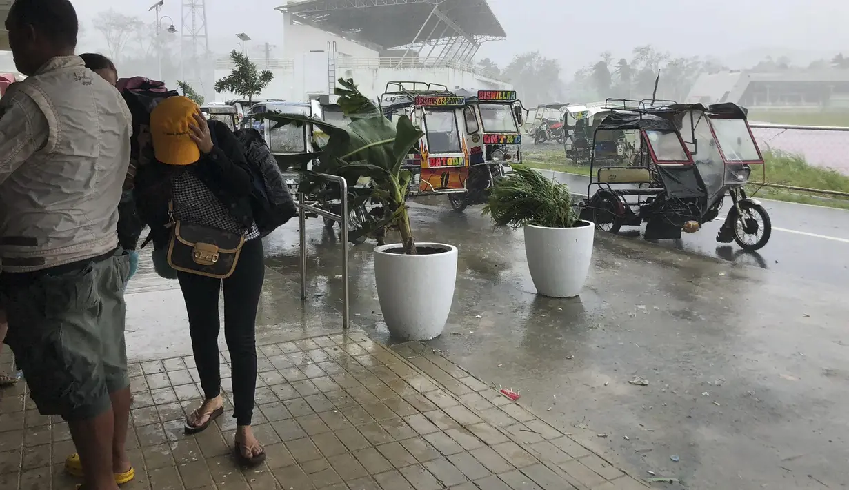 Pengungsi berlindung saat angin kencang bertiup di kota Dapa, Siargao, provinsi Surigao del Norte, Filipina selatan, Kamis (16/12/2021). Puluhan ribu orang sedang dievakuasi ke tempat yang aman ketika Topan Rai mendekati pada Kamis (16/12). (AP Photo)
