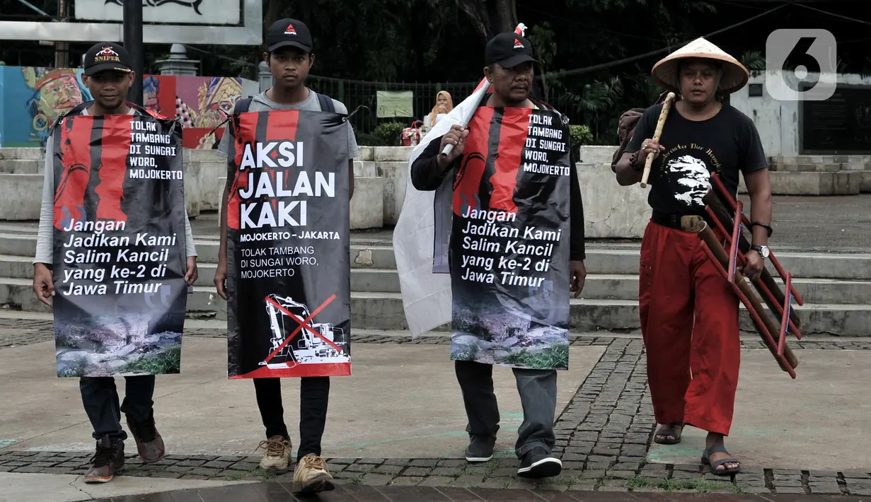 Tiga warga Mojokerto, Ahmad Yani (45), Sugiantoro (31), dan Heru Prasetiyo (24) bersama aktivis saat tiba di seberang Istana Negara, Jakarta, Kamis (6/2/2020). Mereka berjalan kaki dari Mojokerto meminta pemerintah menghentikan aktivitas penambangan di Sungai Woro. (merdeka.com/Iqbal S Nugroho)