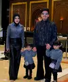 Aurel tampil chic dengan atasan abu-abu bertekstur yang dipadukan dengan celana hitam berpotongan sleek, sementara hijab hitamnya memberi sentuhan klasik yang rapi. [@aurelie.hermansyah],