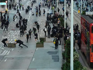 Demonstran memblokade jalan raya dengan batu bata, Hong Kong, Senin (11/11/2019). Ketegangan di Hong Kong semakin meningkat setelah polisi menembak seorang demonstran hingga kritis. (AP Photo/Vincent Yu)