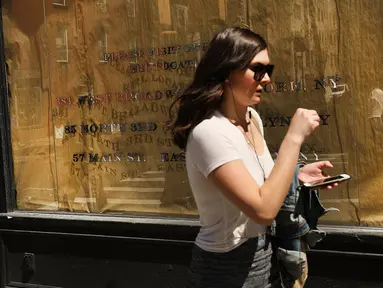 Seorang wanita berjalan di depan sebuah toko yang tutup di West Village, New York (11/4). Menurut Badan Real Estate New York (REBNY), jumlah toko tutup di New York terus meningkat. (Spencer Platt / Getty Images / AFP)