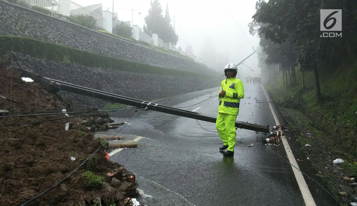 Petugas kepolisian berjaga di dekat lokasi longsor yang terjadi di kawasan Puncak Bogor, Jawa Barat (5/2). Longsor tersebut diduga karena hujan lebat yang mengguyur kawasan Bogor dan sekitarnya. (Foto: Lantas Bogor)