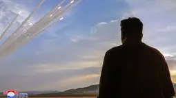 Foto-foto yang dirilis oleh media pemerintah menunjukkan Kim menyaksikan dari kejauhan setidaknya 18 proyektil yang melayang setelah ditembakkan dari truk peluncur. (STR / KCNA VIA KNS / AFP)