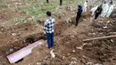 Kerabat mengumandangkan adzan saat pemakaman korban Covid-19 di TPU Srengseng Sawah 2, Jagakarsa, Jakarta, Senin (17/5/2021). Hari ini seluruh TPU di wilayah DKI dibuka untuk umum dengan menerapkan protokol kesehatan seperti pembatasan pengunjung dan waktu berziarah. (merdeka.com/Arie Basuki)