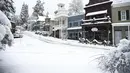 Jalanan utama yang dipenuhi salju pada Senin pagi di Nevada City, California (27/12/2021). Hujan salju dingin membuat perjalanan hampir tidak mungkin dilakukan di beberapa bagian California, Nevada. (Elias Funez/The Union via AP)