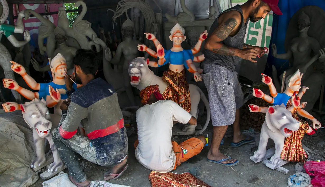 Pematung Nepal Ravi Pandit (kiri), Puran Pandit (tengah) dan Shyam Pandit memberikan sentuhan akhir kepada berhala Dewa Ganesha menjelang festival Dashain di Kathmandu, Nepal (14/10/2020). (AP Photo/Niranjan Shrestha)