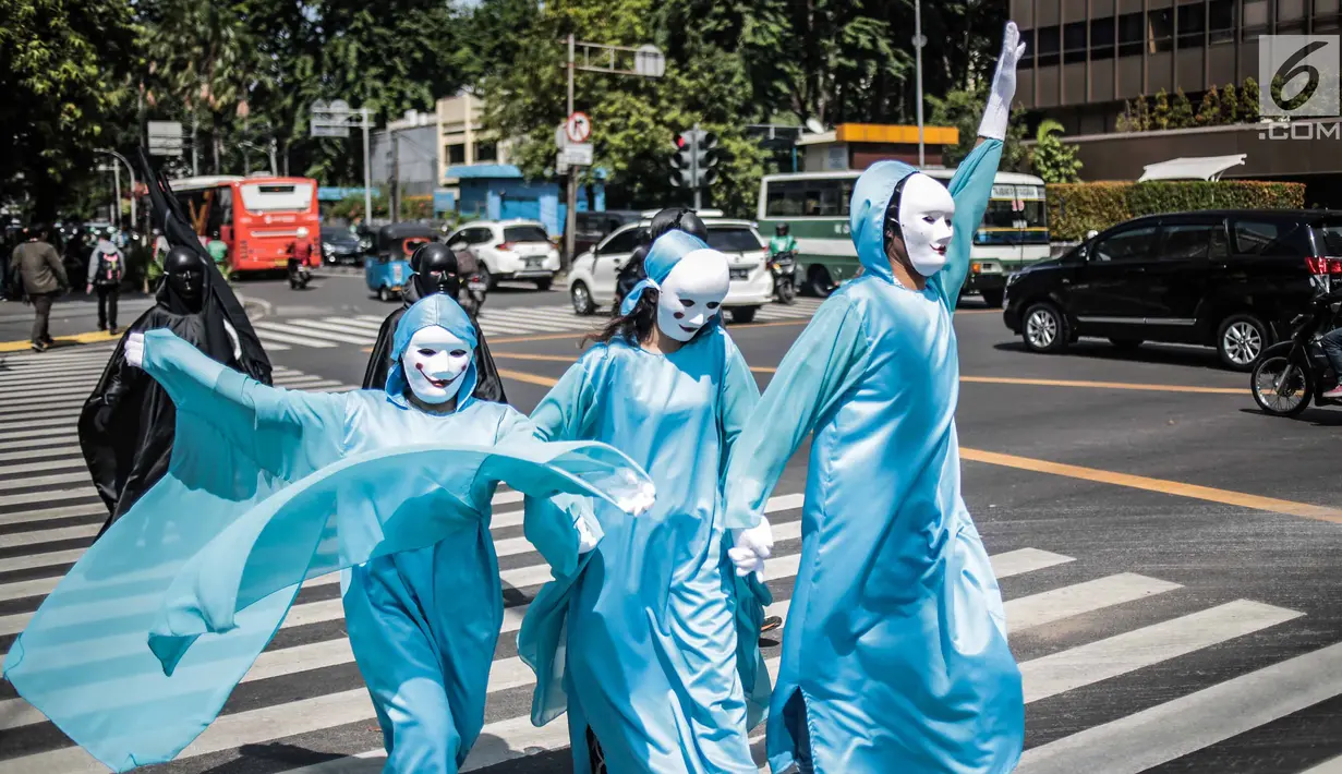 Massa menggelar aksi teatrikal di Pelican crossing di Jakarta, Kamis (20/12). Mereka mengajak pemilih milenial untuk memilih pemimpin yang berorientasi jangka panjang dan berpihak pada energi bersih, adil, dan berkelanjutan. (Liputan6.com/Faizal Fanani)