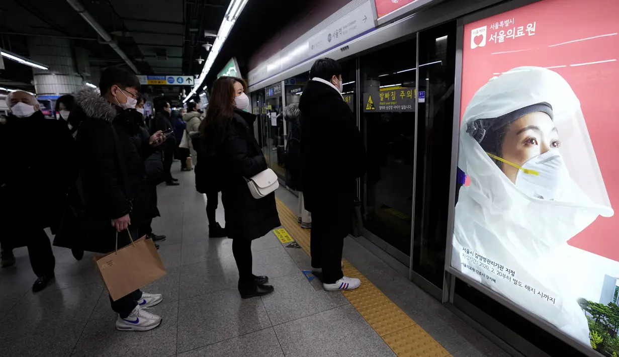 Para penumpang yang mengenakan masker menunggu kereta mereka di stasiun kereta bawah tanah di Seoul, Korea Selatan, Rabu (23/2/2022). Kasus harian COVID-19 baru Korea Selatan mencapai rekor tertinggi, melonjak menjadi 171.452 dari 99.569 kasus sehari sebelumnya. (AP Photo/Ahn Young-joon)