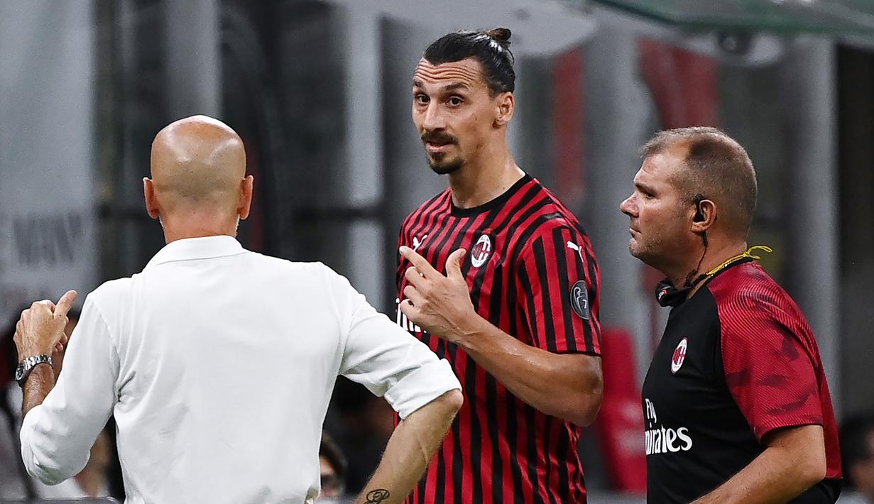 Pelatih AC Milan, Stefano Pioli, berusaha menenangkan Zlatan Ibrahimovic yang kecewa usai diganti saat melawan Bologna pada laga Serie A di Stadion San Siro, Sabtu (18/7/2020). AC Milan menang dengan 5-1 atas Bologna. (AFP/Marco Bertorello)