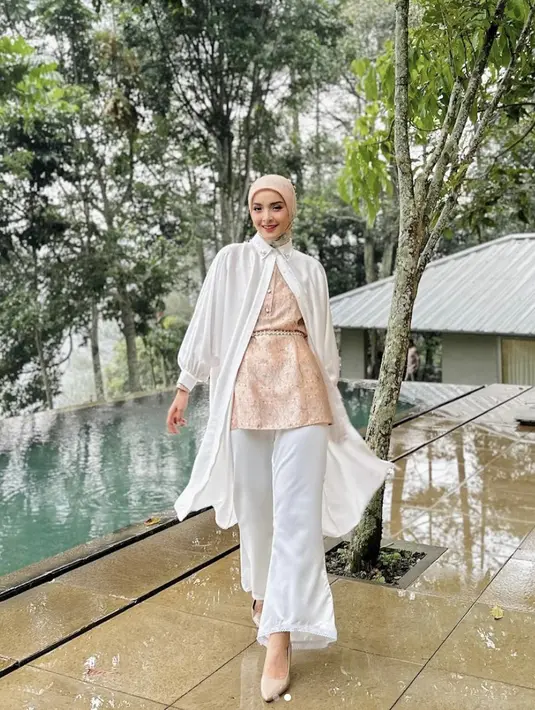 Putih dan peach jadi nuansa warna yang begitu manis. Padukan tunik dengan blouse warna kontras untuk optimasi gaya yang unik. [Foto: Instagram/ Nabila Ishma]
