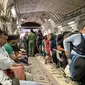 Warga negara India duduk di atas pesawat militer India untuk dievakuasi setelah pengambilalihan Afghanistan oleh pejuang Taliban di bandara di Kabul (17/8/2021).  Sebagian kecil warga India tetap di negara tersebut dan tengah diupayakan untuk dibawa kembali oleh pihak berwenang. (AFP Photo)