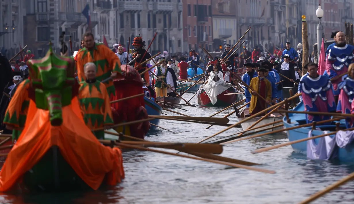 Peserta mendayung perahu menyusuri Grand Canal pada pembukaan karnaval Venesia di Italia, 28 Januari 2018. Karnaval perahu Venisia dengan aneka kostum yang menjadi ciri khasnya terus berlangsung hingga saaat ini. (AFP Photo / FILIPPO MONTEFORTE)