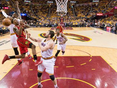 LeBron James (kiri) menghadang tembakanpemain Atlanta Hawks, Jeff Teague #0 pada partai kedua semifinal Wilayah Timur NBA, di Quicken Loans Arena, Kamis (5/5/2016) WIB.  Jason Miller/Getty Images/AFP