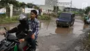 Kendaraan menghindari kubangan pada jalan yang rusak di Jalan Pertamina, Kemiri Muka, Depok, Jawa Barat, Selasa (5/3). Jalan rusak yang telah berlangsung bertahun-tahun tersebut tak kunjung diperbaiki. (Liputan6.com/Immanuel Antonius)