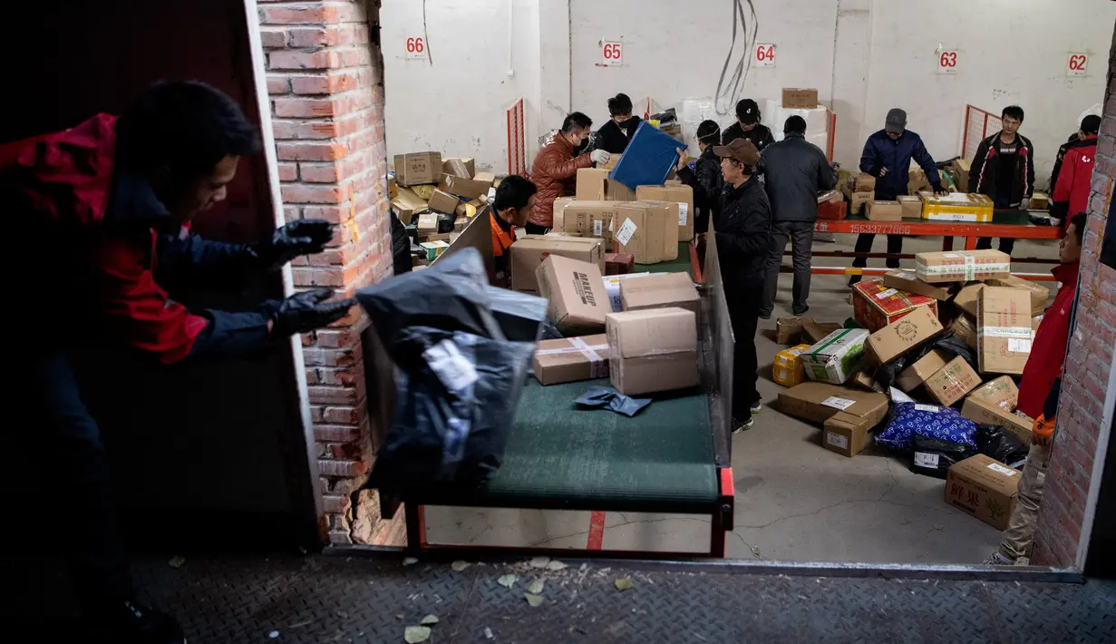 Para pekerja ekspedisi sibuk memilah paket untuk dikirim ke pelanggan saat Singles Day di Beijing, China, Senin (11/11/2019). Singles Day menjadi pesta belanja online terbesar di dunia. (NOEL CELIS/AFP)