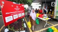 Warga usai membeli paket sembako di Bazar Ramadan Sembako Murah LRT Jakarta di Jakarta Utara, Senin (25/3/2024). (Liputan6.com/Angga Yuniar)