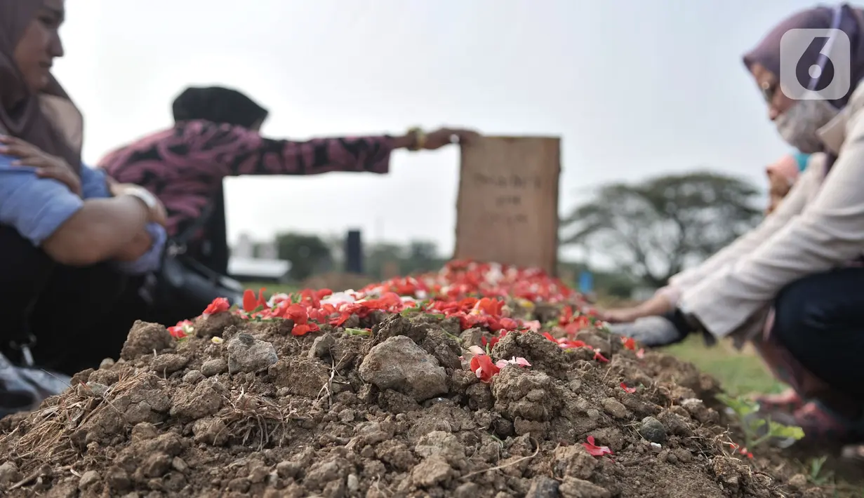 Keluarga korban meninggal Covid-19 saat berziarah di TPU Tegal Alur, Jakarta, Kamis (25/6/2020). Menurut petugas makam TPU Tegal Alur, selama masa PSBB Transisi jumlah pemakaman jenazah dengan protap Covid-19 meningkat dibanding bulan lalu. (merdeka.com/Iqbal S Nugroho)