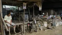 Seorang pria duduk di samping sisa-sisa rumah yang rusak di kota Talisay, provinsi Cebu, Filipina tengah, Jumat (17/12/2021). Lebih dari 300.000 penduduk desa telah melarikan diri ke tempat yang aman sebelum terjangan Topan Rai. (AP Photo/Jay Labra)