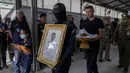 Anggota pasukan khusus Thailand membawa potret seorang perwira, korban penembakan massal di Korat, Nakhon Ratchasima, Thailand, Senin, (10/2/2020). Pelaku penembakan massal, Jakraphanth Thomma berhasil ditembak mati oleh petugas. (AP Photo/Gemunu Amarasinghe)