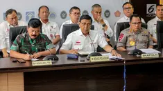 Menko Polhukam Wiranto (tengah) bersama Panglima TNI Marsekal Hadi Tjahjanto (kiri) dan Kapolri Tito Karnavian (kanan) memberi keterangan usai rapat koordinasi tertutup di Kantor Kemenko Polhukam, Jakarta, Selasa (24/9/2019). Rapat membahas isu-isu nasional terkini. (Liputan6.com/Faizal Fanani)