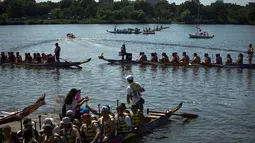 Para peserta bersiap memulai balapan pada Festival Perahu Naga Hong Kong yang digelar di Queens, New York, Minggu (13/8). Lebih dari 120 tim asal Amerika Utara berpartisipasi dalam perlombaan tersebut. (AP/Andres Kudacki)