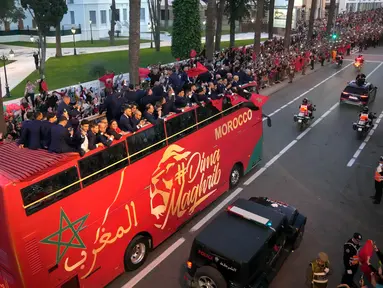 Para pemain timnas Maroko melakukan selebrasi di atas bus dan melambaikan tangan ke publik saat parade di Rabat , Maroko, 20 Desember 2022. Timnas Maroko mendapat sambutan hangat di negaranya setelah berhasil meraih juara keempat Piala Dunia 2022. (AP Photo/Mosa'ab Elshamy)