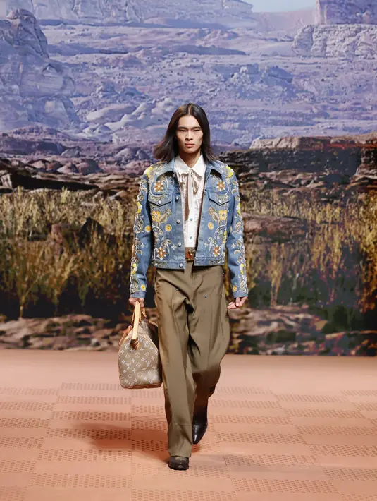 Lukisan koboi asli diadaptasi menjadi permadani jacquard yang digunakan pada jas hujan, kanvas kering digunakan dalam jaket bersulam tali, dan cetakan pada pakaian yang sudah tua, seolah terkikis sinar matahari. [Foto: Document/Louis Vuitton]