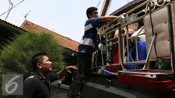 Warga memasukan barang-barang ke dalam mobil truk TNI usai dilakukan pengosongan oleh Komando Daerah Militer Jayakarta (Kodam Jaya), Jakarta, Kamis (3/9/2015). Sebanyak 99 rumah dikosongkan oleh Kodam Jaya. (Liputan6.com/Yoppy Renato)