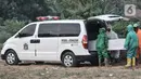 Petugas mengenakan APD saat mengeluarkan jenazah korban Covid-19 dari ambulans di TPU Tegal Alur, Jakarta, Kamis (25/6/2020). Menurut petugas makam TPU Tegal Alur, selama masa PSBB Transisi jumlah pemakaman jenazah dengan protap Covid-19 meningkat dibanding bulan lalu. (merdeka.com/Iqbal S Nugroho)