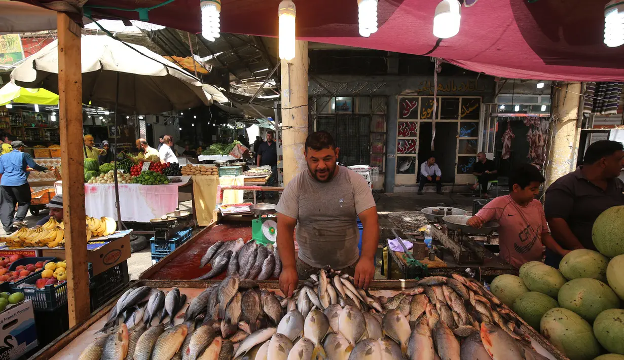 Seorang pedagang menjual ikan di pasar populer di Baghdad (24/5/2019). Umat Muslim di seluruh dunia tengah melaksanakan puasa dimana mereka tidak makan, minum mulai dari matahari terbit hingga terbenam. (AFP Photo/Ahmad Al-Rubaye)