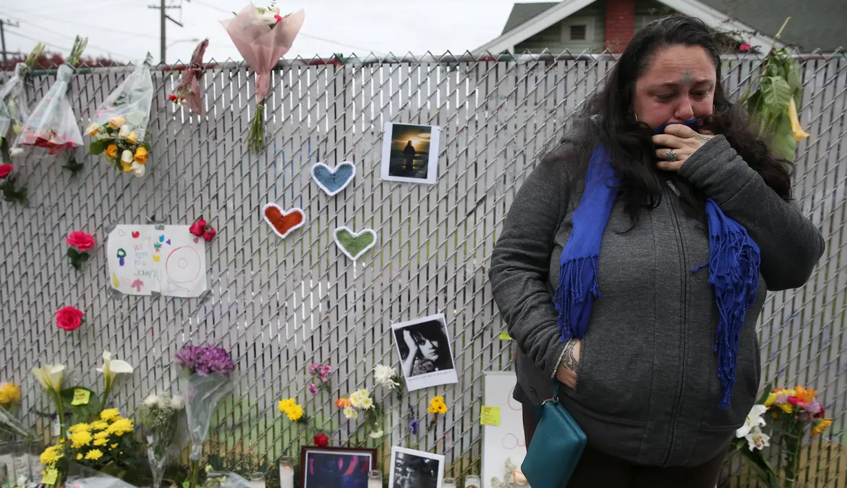 Seorang wanita menangis saat berada di tempat peringatan Gudang Terbakar di California, AS, Senin (5/12). Setidaknya ada 30 korban yang tewas dalam peristiwa kebakaran tersebut. (REUTERS / Lucy Nicholson)