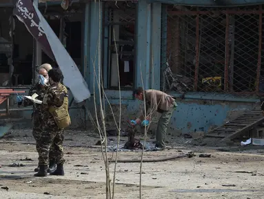 Petugas memeriksa lokasi serangan bom bunuh diri di daerah Syiah di Kabul (9/3). Seorang pembom bunuh diri yang menargetkan kelompok minoritas Afghanistan, Hazaras, meledakkan dirinya di sebuah pos pemeriksaan polisi. (AFP Photo/Shah Marai)