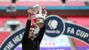 Pelatih Arsenal, Mikel Arteta mengangkat trofi Piala FA setelah mengalahkan Chelsea pada pertandingan final Piala FA di stadion Wembley, London, Minggu (2/8/2020) dini hari. Arsenal juara Piala FA setelah menang dengan skor 2-1. (Catherine Ivill/Pool via AP)