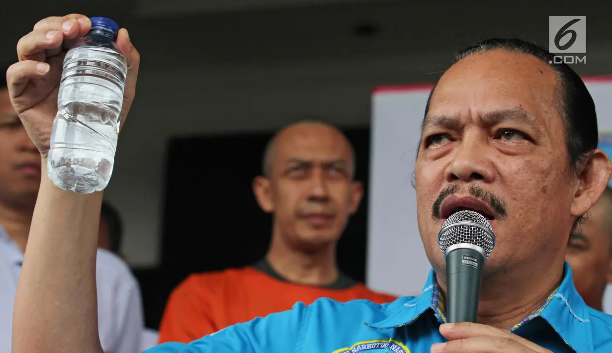 Deputi Pemberantasan BNN, Irjen Pol. Arman Depari menunjukkan barang bukti narkotika cair saat rilis di Jakarta, Kamis (21/12). Sekitar 80 botol air berisi narkotika cair diamankan dari diskotek MG International Club. (Liputan6.com/Herman Zakharia)