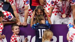 Kapten Kroasia, Luka Modric mencium anaknya, Ivano saat timnya berhasil menyabet peringkat ketiga Piala Dunia 2022 setelah mengalahkan Maroko dengan skor 2-1 pada laga yang berlangsung di Khalifa International Stadium, Doha, Qatar, Sabtu (17/12/2022). (AP Photo/Hassan Ammar)