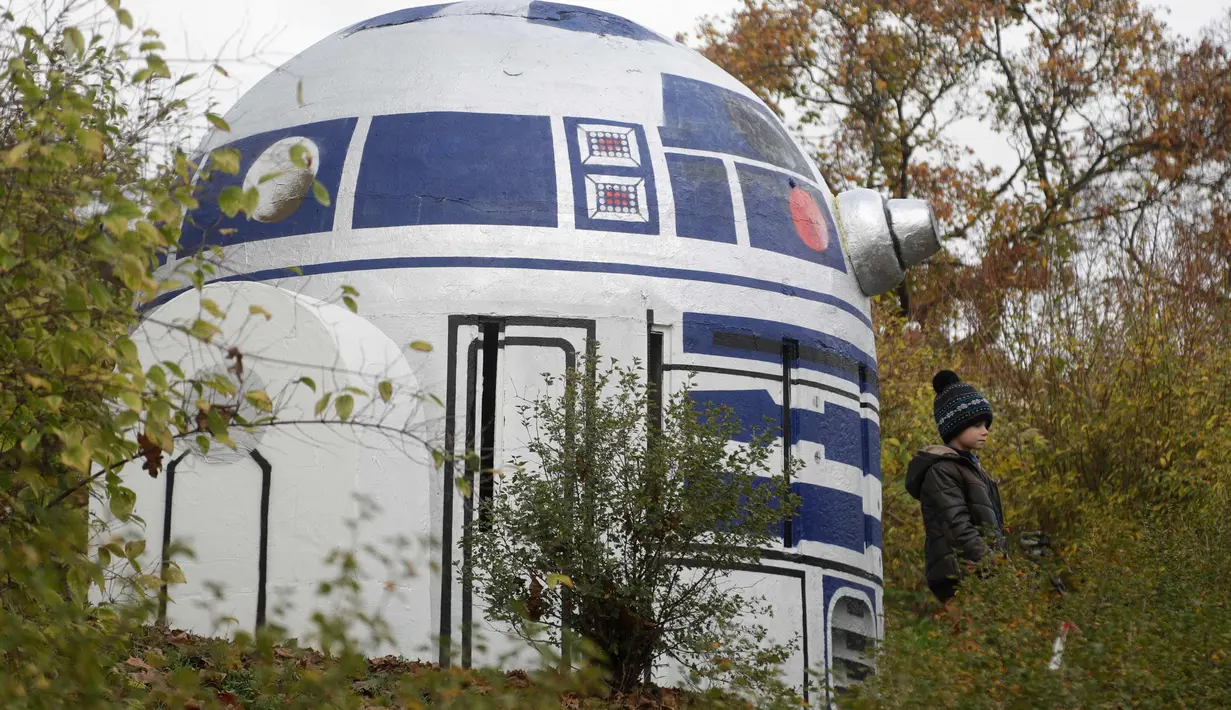 Seorang anak berada di dekat ventilasi bunker nuklir yang menyerupai robot R2-D2 film Star Wars di sebuah taman di Praha, Republik Ceko, (28/10). Kreatifitas seniman tersebut menghebohkan warga Praha. (AP Photo/Petr David Josek)