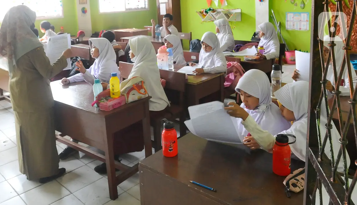Siswa mengikuti ujian penilaian akhir semester (PAS) yang dihadiri guru pengawas di SDN Pondok Cina 1 Depok, Jawa Barat, Senin (5/12/2022). Guru SDN Pondokcina 1 Depok kembali hadir di sekolah itu pada hari ini. (merdeka.com/Arie Basuki)