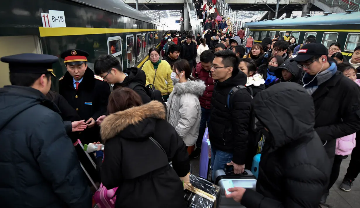 Calon penumpang antre untuk menaiki kereta di sebuah stasiun di Fuyang, Provinsi Anhui, China, Minggu (10/2). Jutaan warga China mulai kembali bekerja setelah menghabiskan liburan Tahun Baru Imlek di kampung halaman. (Chinatopix via AP)