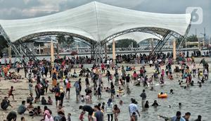 Wisatawan memadati Pantai Ancol saat mengisi libur Natal, Jakarta, Minggu (25/12/2022). Kepala Komunikasi PT Pembangunan Jaya Ancol Ariyadi Eko Nugroho mengungkapkan per hari ini jumlah wisatawan di Taman Impian Jaya Ancol tembus 40.000, angka tersebut meningkat dua kali lipat dibanding libur hari biasa maupun Natal tahun 2021. (merdeka.com/Iqbal S. Nugroho)