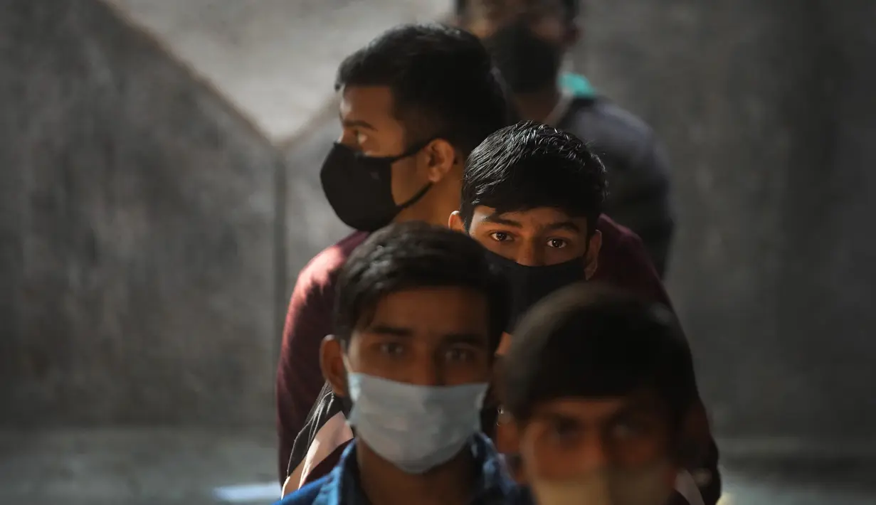 Anak-anak menunggu untuk menerima vaksin COVID-19 mereka di sebuah sekolah negeri di New Delhi, Senin (3/1/2022). India mulai memvaksinasi remaja usia 15-18 tahun saat banyak negara bagian memberlakukan pembatasan ketat untuk menahan lonjakan kasus omicron. (AP Photo /Manish Swarup)