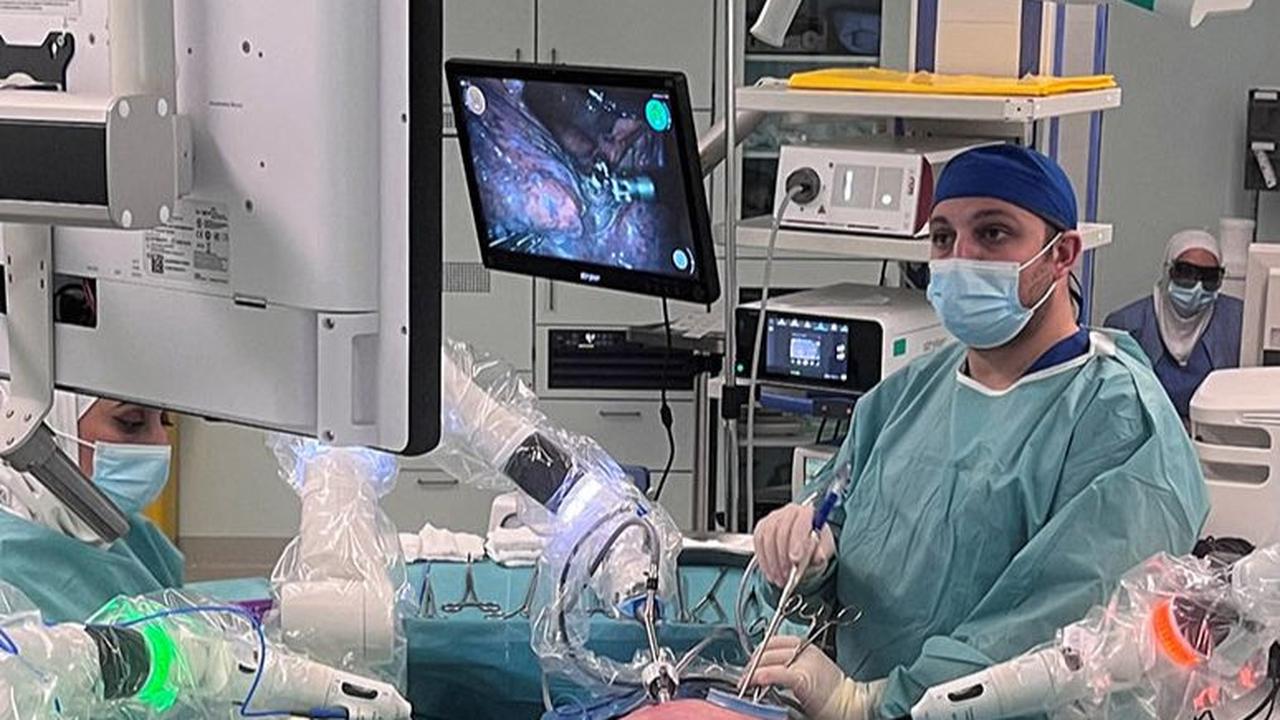 Tampak tiga robot berbentuk lengan atau arm robot melakukan tindakan operasi dengan dikendalikan oleh dokter.
