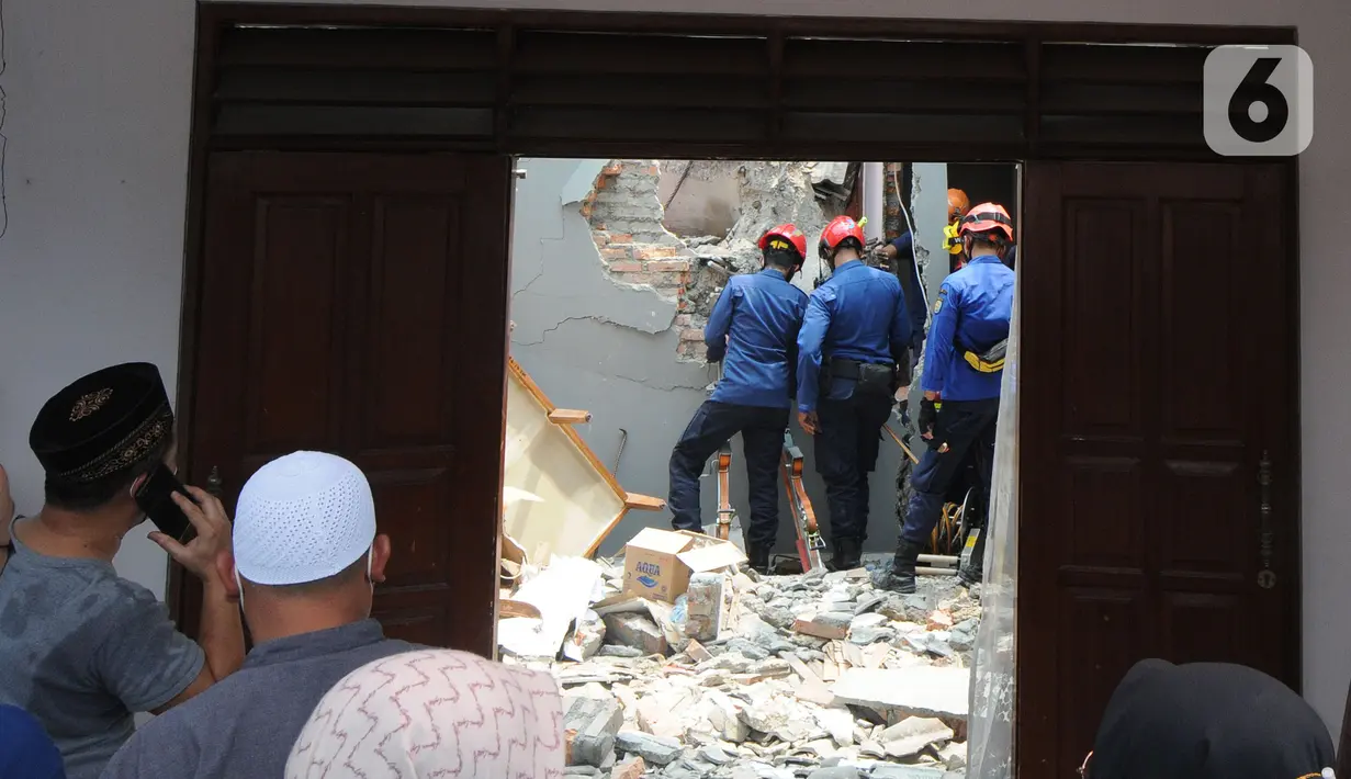 Petugas Damkar berusaha mengevakuasi anak berusia 12 tahun yang tertimpa beton akibat tergulingnya truk crane di Jalan Mawar, Perumnas Depok Jaya, Depok, Jawa Barat, Jumat (15/10/2021). (merdeka.com/Arie Basuki)